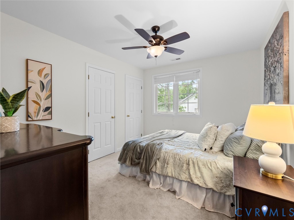 Recessed window with white blinds, ceiling fan with integrated lighting, two paneled doors, and neutral wall paint