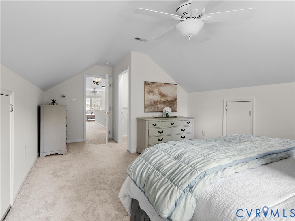 Carpeted flooring, vaulted ceiling, and built-in ceiling fan with lighting