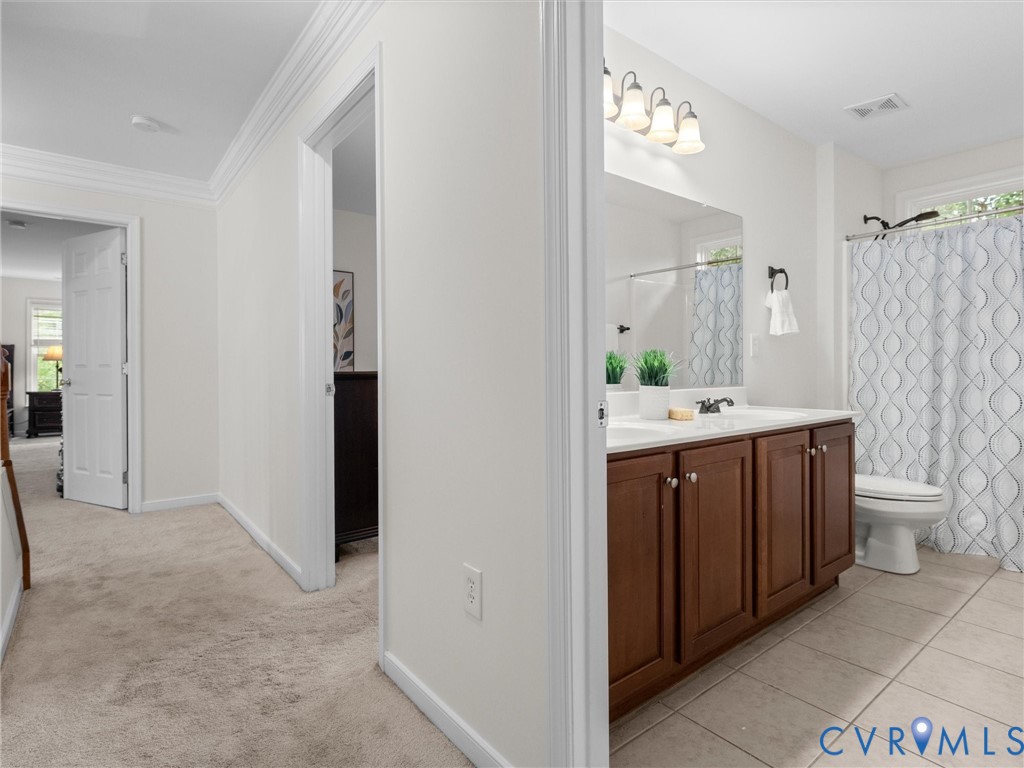 Hallway with carpet flooring and crown molding