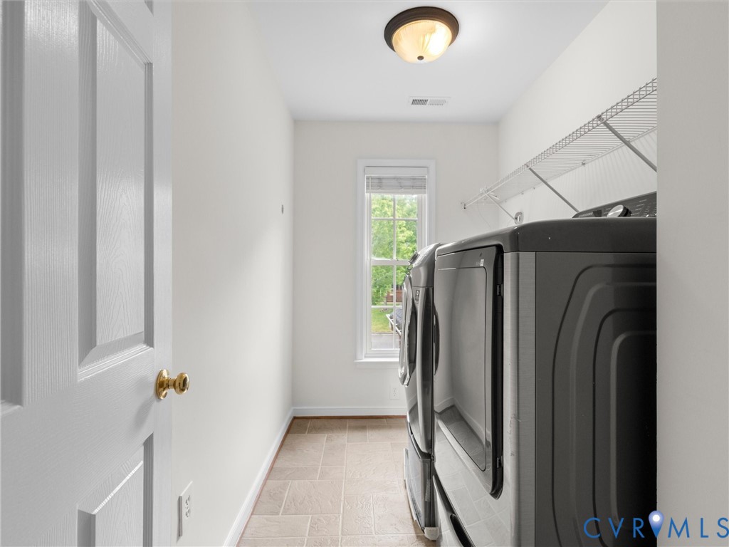 Utility room featuring tile flooring, a window, a flush-mount ceiling light, and wall-mounted wire shelving