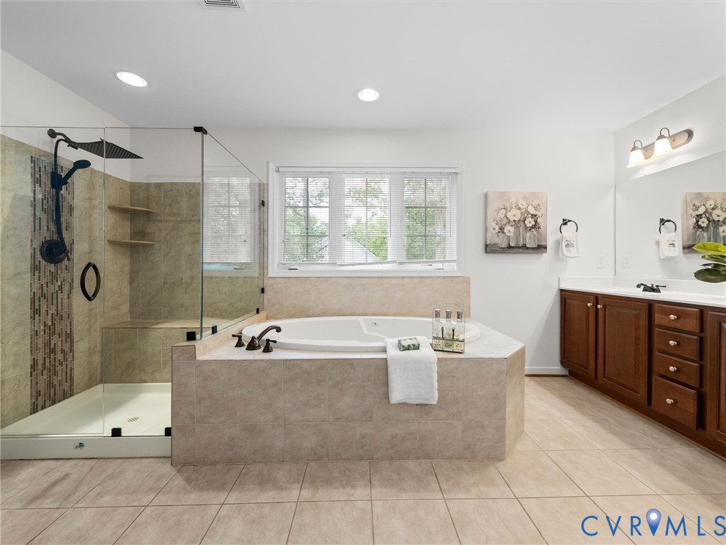 Tiled flooring leading to a walk-in shower with a glass enclosure and bench seating