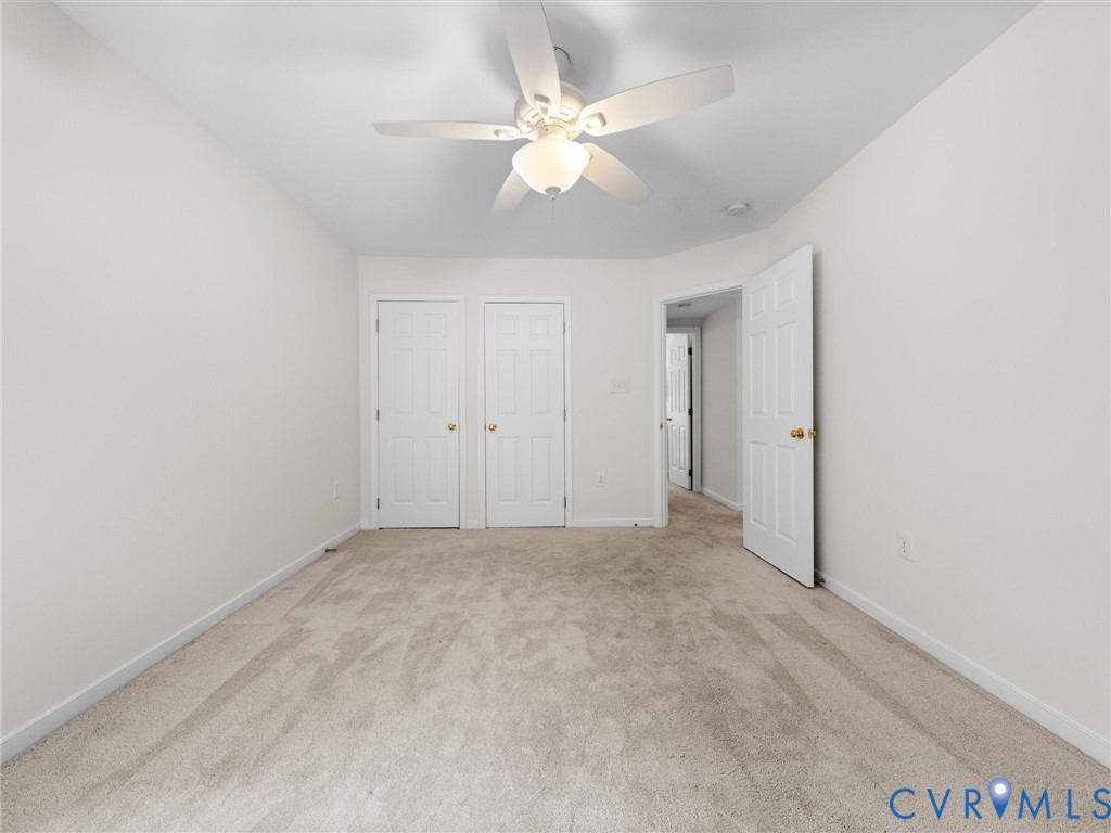 Plush carpeting, recessed ceiling, white interior doors, and a ceiling fan with integrated lighting