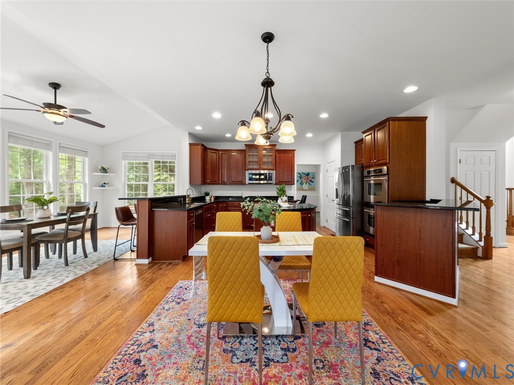 Hardwood flooring throughout, a kitchen featuring dark wood cabinetry, and a double wall oven