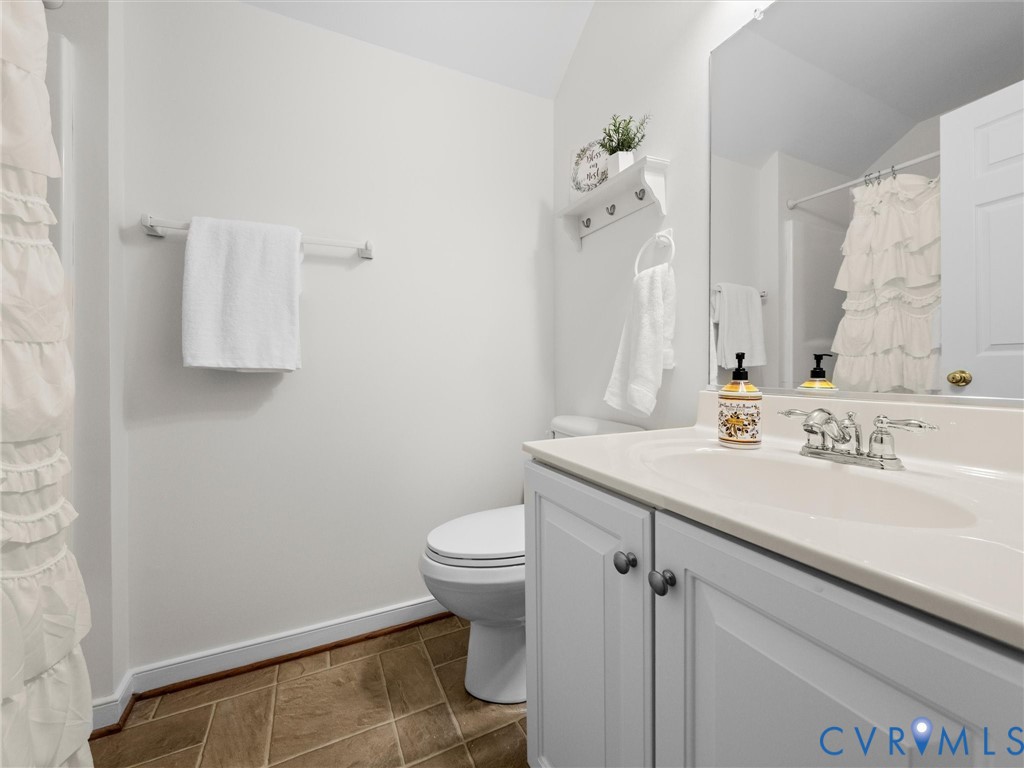 White vanity with a single basin sink, chrome faucet, and integrated countertop