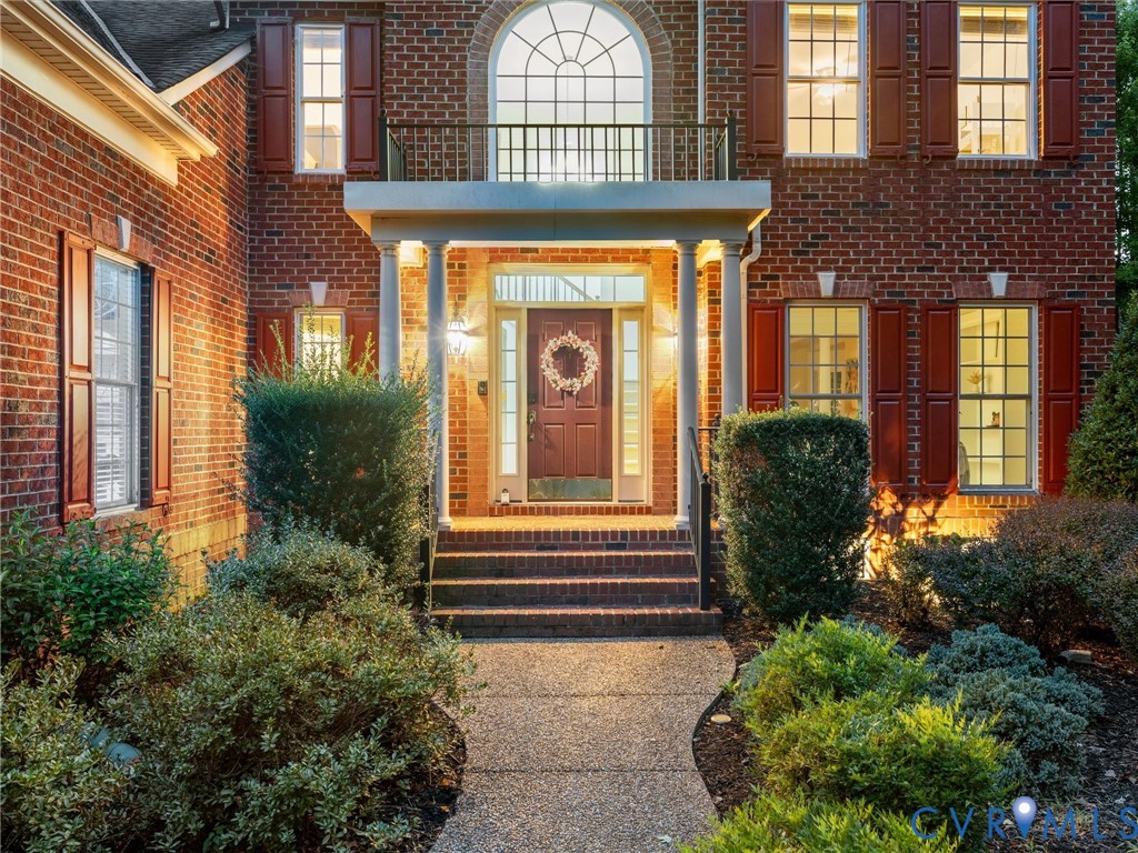 Brick exterior with a covered entry, arched window, and decorative shutters