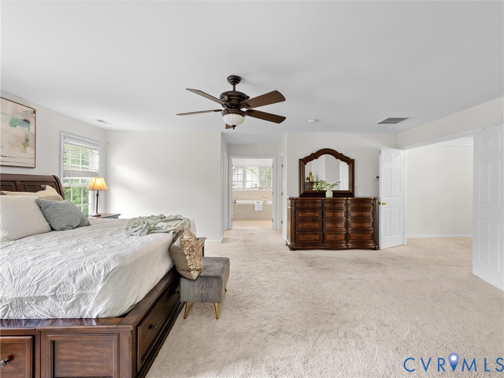 Carpeted flooring, ceiling fan, white paneled doors, and a window with blinds