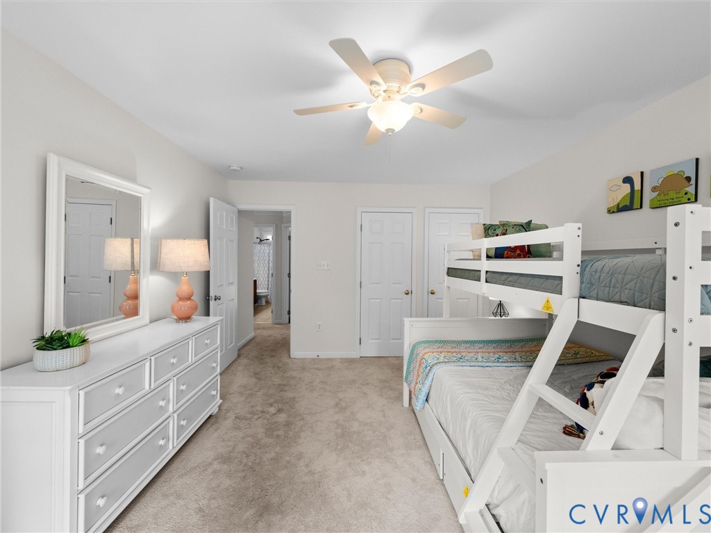 Neutral wall tones, carpet flooring, a ceiling fan with integrated lighting, and white interior doors