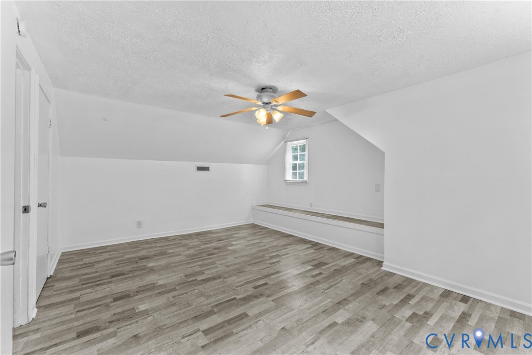 Sloped ceilings, wood-finish flooring, and a built-in window bench
