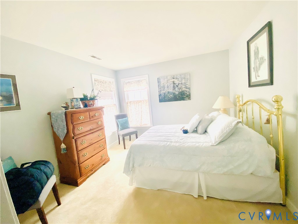 Light-filled room featuring neutral wall tones and a soft, neutral carpet