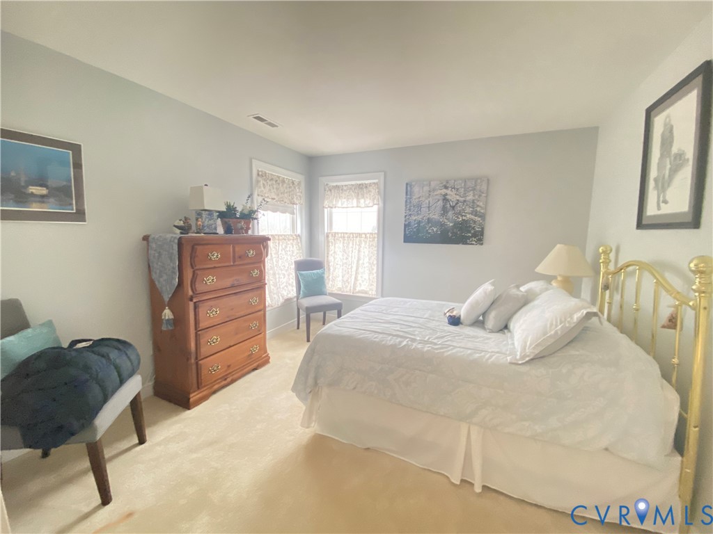 Carpeted room featuring multiple windows with valances and light-colored walls