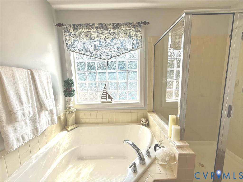 Soaking tub with tile surround, paired with a glass-enclosed shower