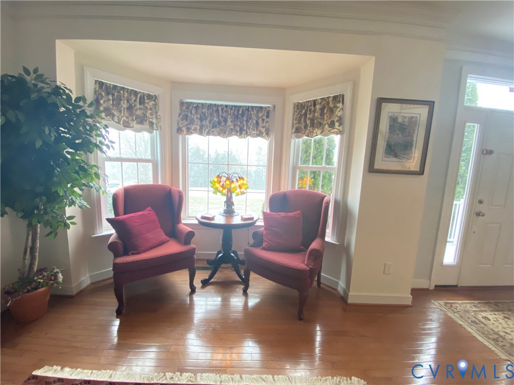 Bay window seating area featuring a multi-pane window configuration and wood-finish flooring