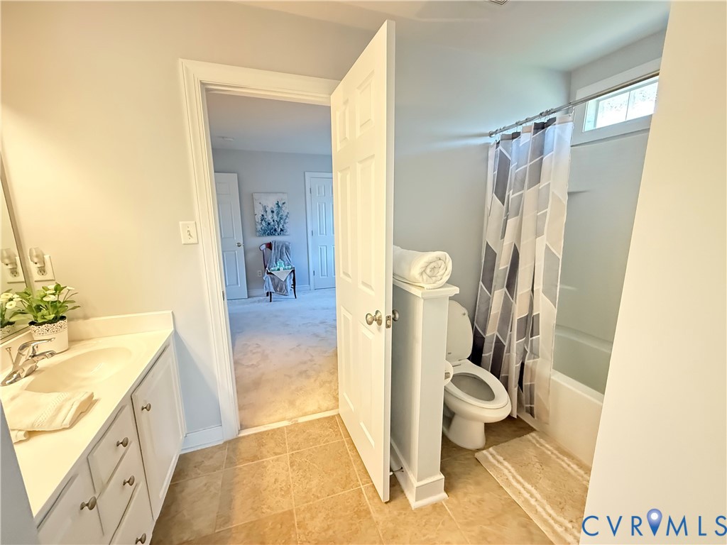 Bathroom featuring a single vanity with an undermount sink, a white countertop, and white cabinetry