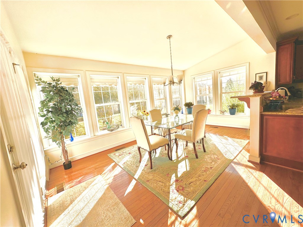 Dining area with wood-finish flooring and extensive windows