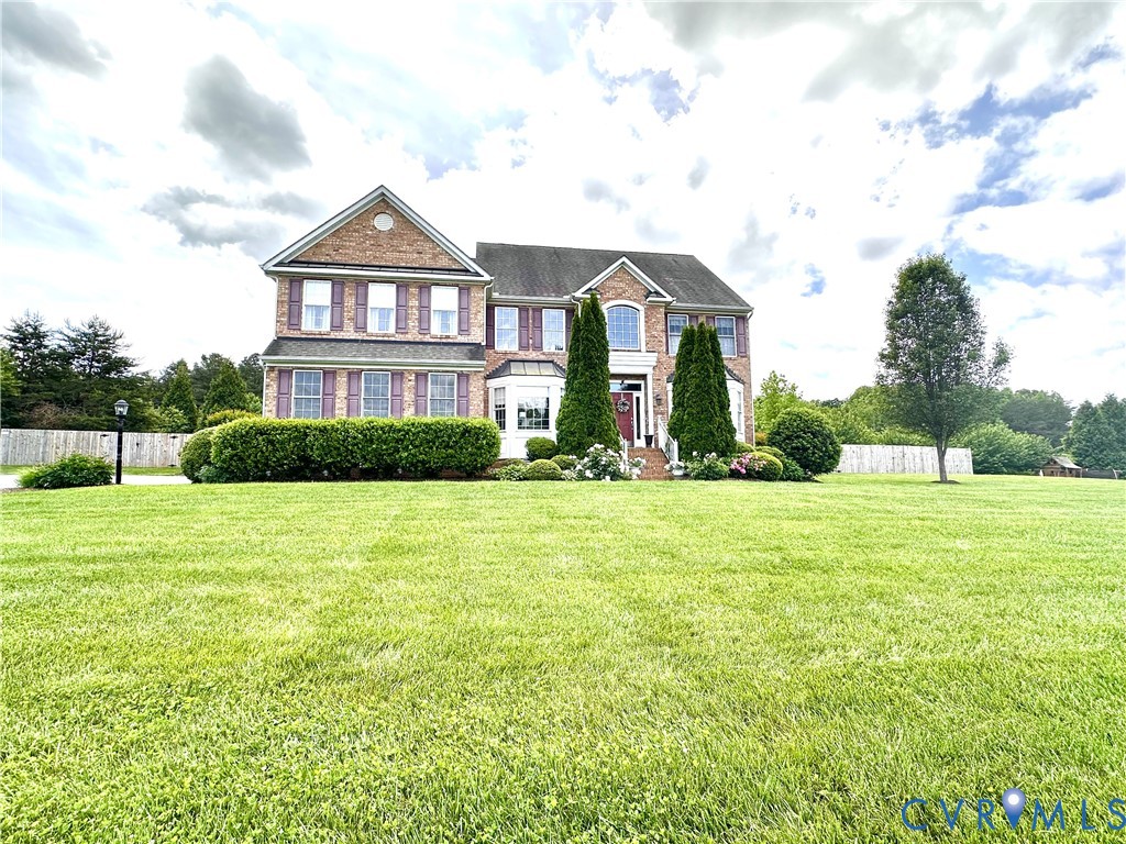 Brick facade residence featuring a prominent bay window, decorative shutters, and a covered entry
