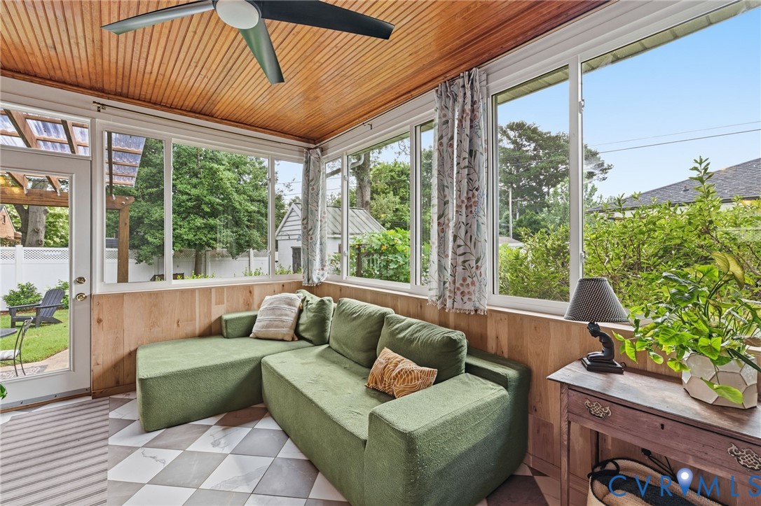 Screened porch featuring a wood-finish plank ceiling and a ceiling fan
