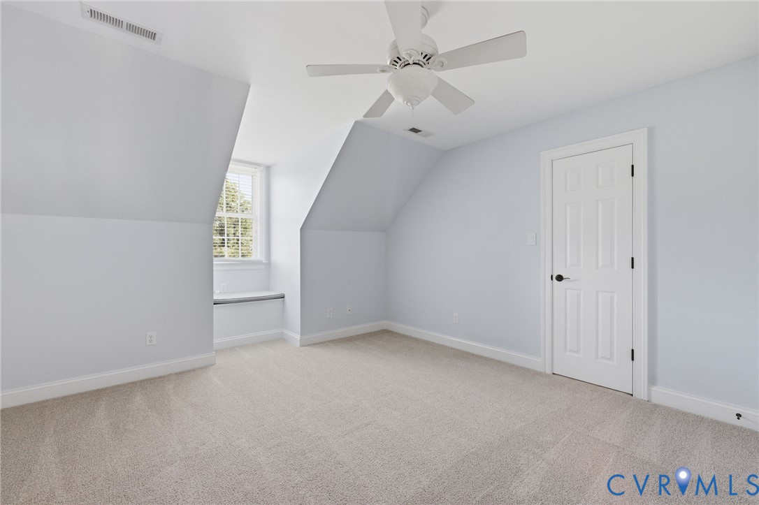 Carpeted room featuring a ceiling fan, recessed window, and white trim