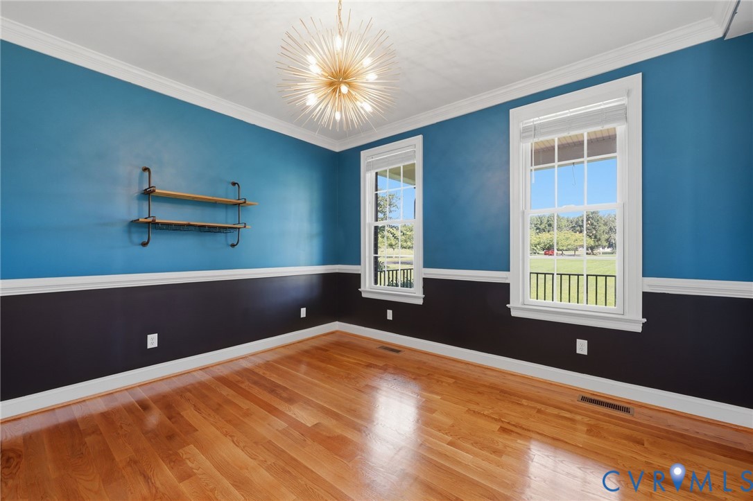 Hardwood flooring complemented by a two-tone wall treatment and white crown molding
