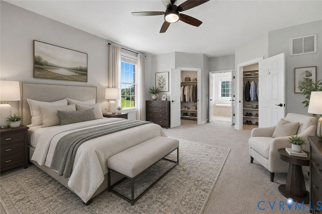 Spacious bedroom featuring light gray walls, large window with outdoor scenery, ceiling fan with integrated lighting, and carpeted flooring