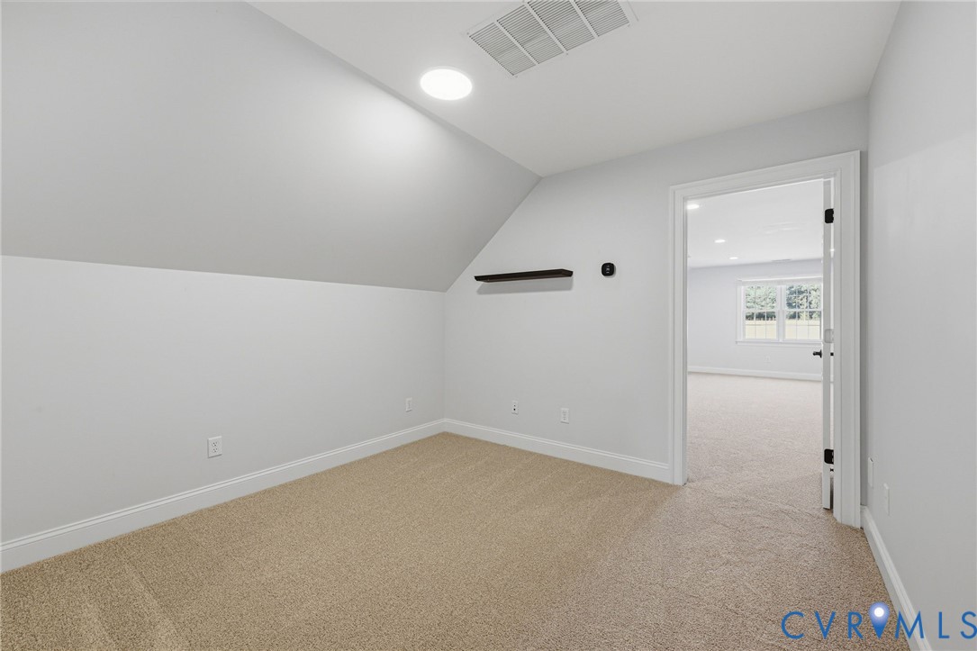Loft/Office Carpeted room with a sloped ceiling and recessed lighting