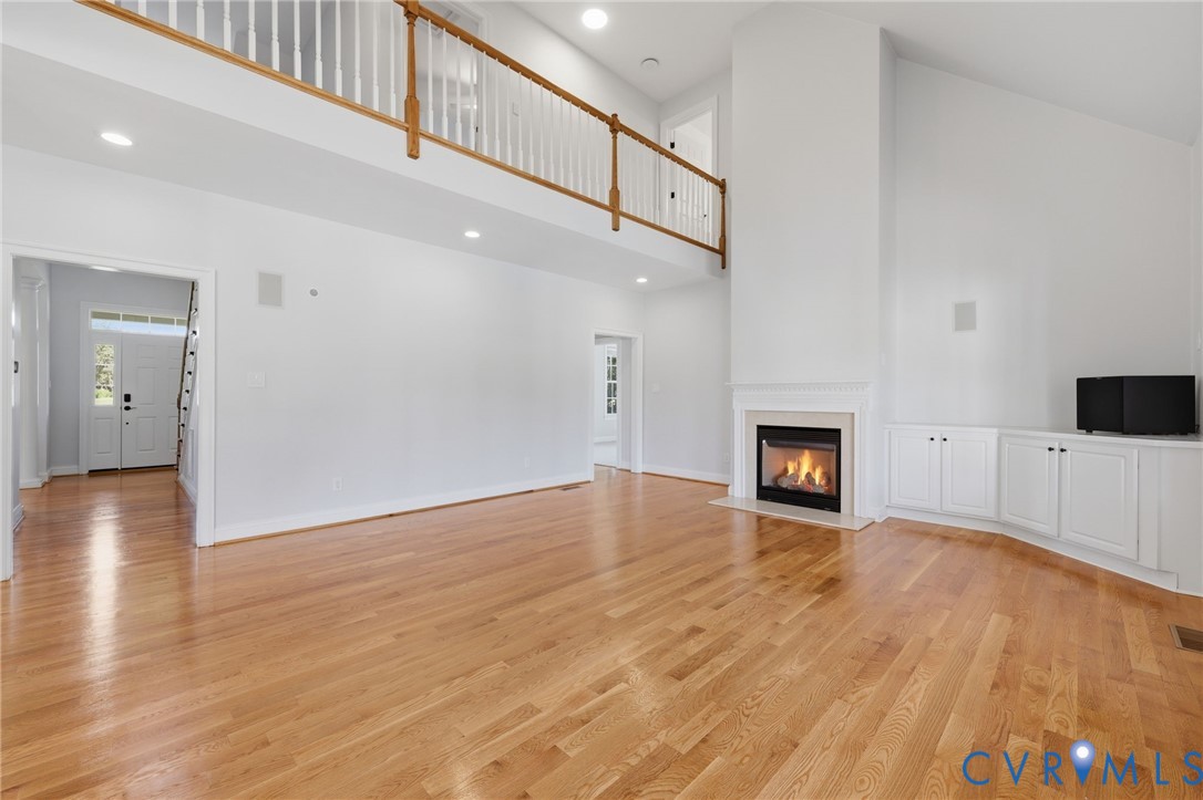 Expansive living space featuring light wood-finish flooring and a high vaulted ceiling