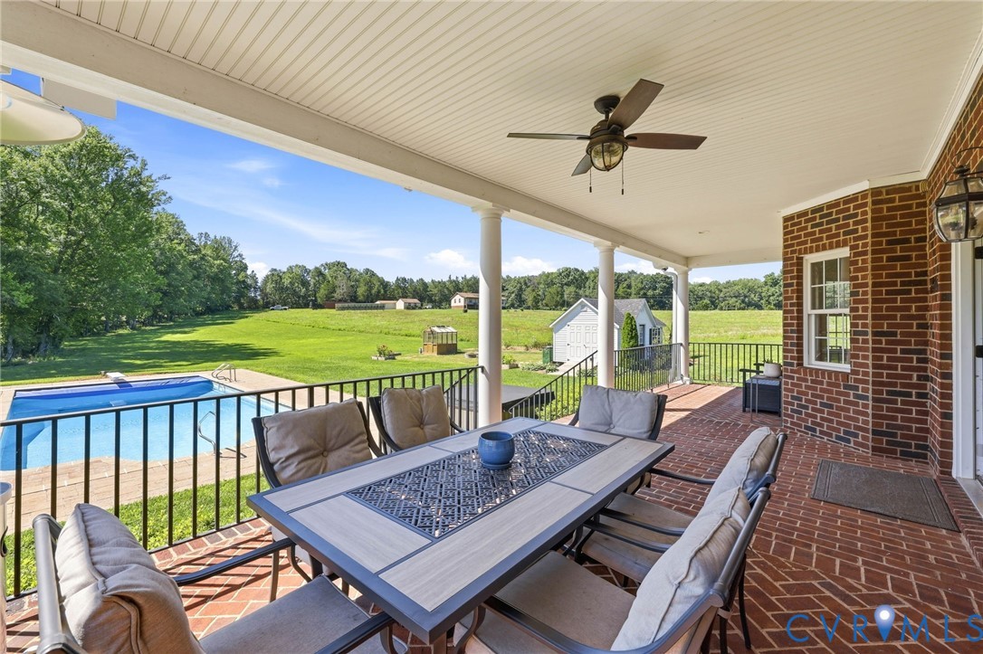 Expansive covered porch featuring a red brick flooring pattern