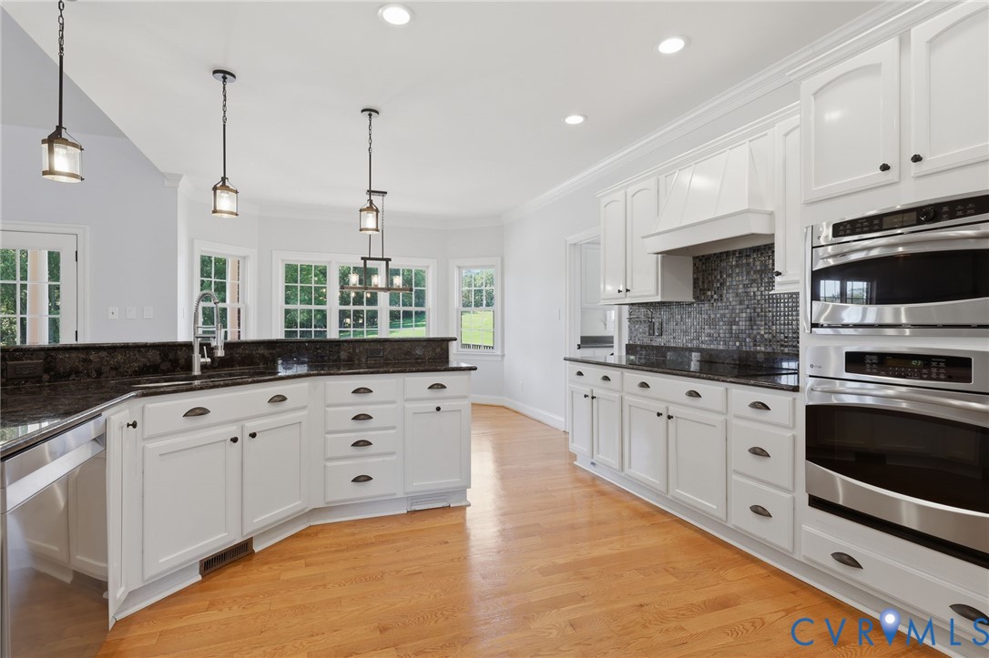 Spacious kitchen featuring light wood-finish flooring and white cabinetry