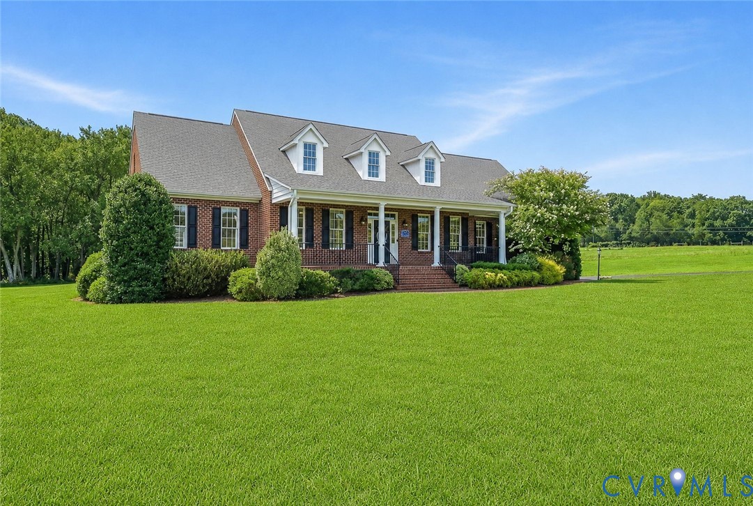 Brick exterior with white columned front porch and dormer windows Brick exterior with white columned front porch and dormer windows