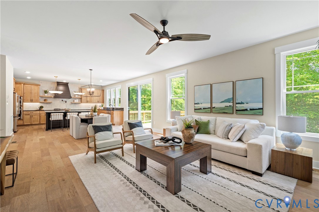 Open-concept living space with light wood-finish flooring, recessed lighting, and a contemporary ceiling fan