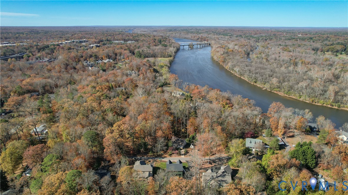 Expansive property featuring mature trees, a river, and a bridge