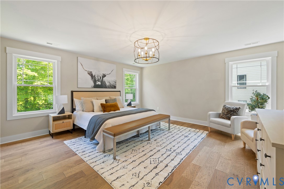 Spacious room featuring wood-finish flooring and multiple windows with white trim