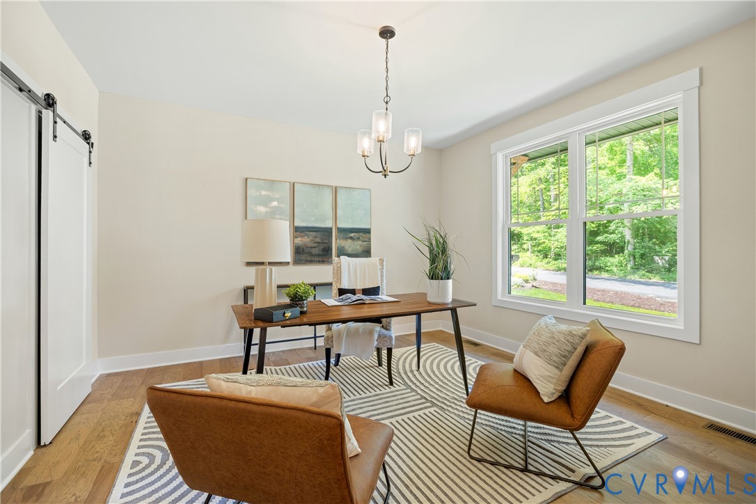 Room featuring wood-finish flooring, a contemporary chandelier, and a large window with white trim