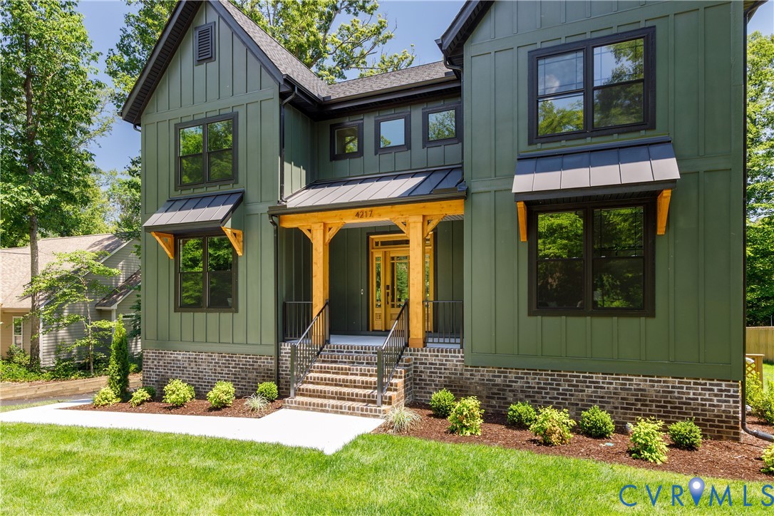 Modern farmhouse exterior featuring vertical board and batten siding in a deep green hue