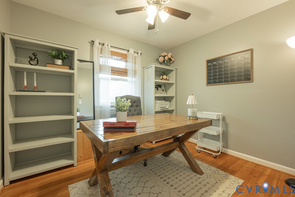 Bedroom with closet and ceiling fan setup as an office