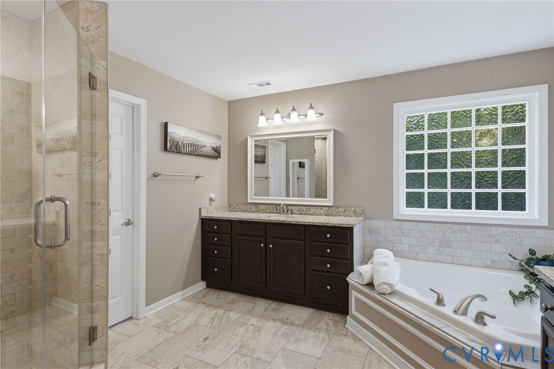 Tiled walk-in shower with glass enclosure and built-in bench