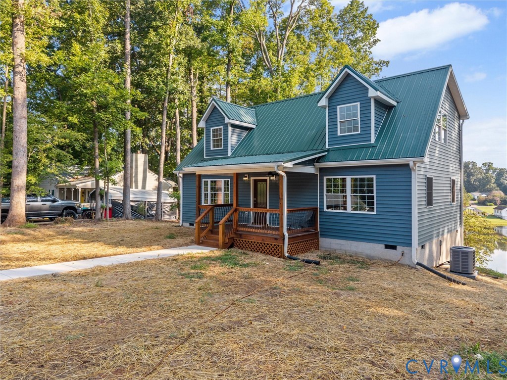 Two-story home featuring blue siding and a green metal roof