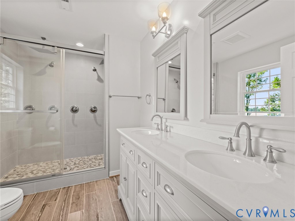 Dual-sink vanity with a white countertop and brushed nickel fixtures, complemented by two framed mirrors
