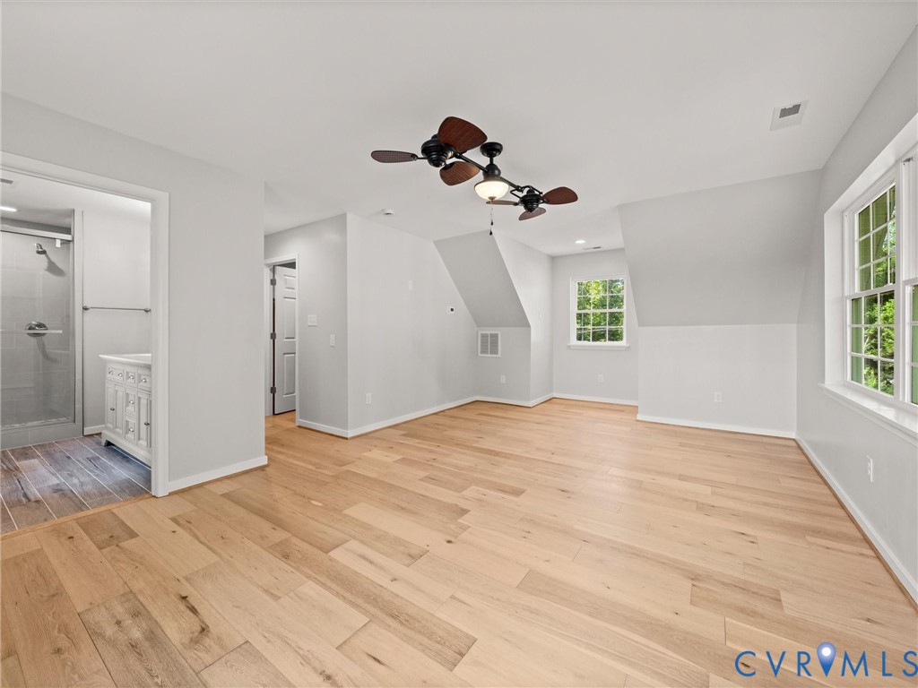 Hardwood flooring, multiple windows, ceiling fans, recessed lighting, and an attached bathroom with a shower