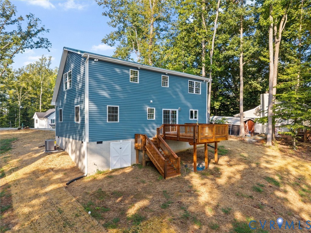 Expansive rear deck with wooden railing and stairs, offering outdoor living space