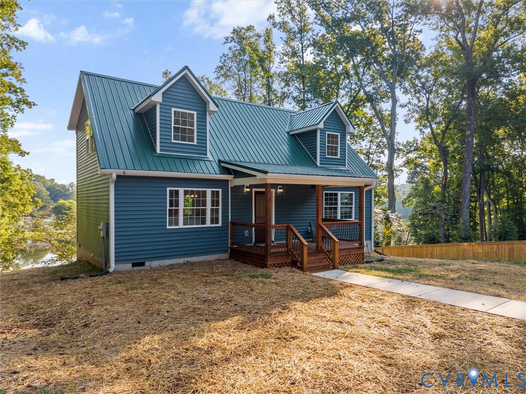 Blue siding with a green metal roof and white trim