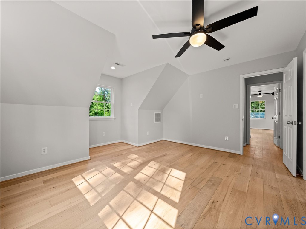 Hardwood-finish flooring, recessed lighting, ceiling fan with integrated light, sloped ceilings, and window