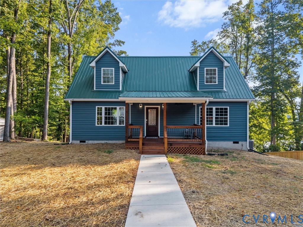Blue horizontal siding exterior with a green metal roof