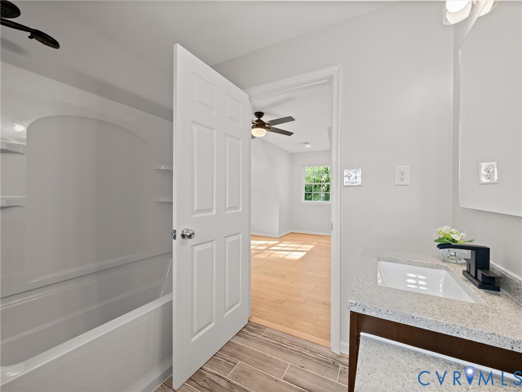 White vanity with a rectangular basin sink, black single-handle faucet, and light-toned countertop