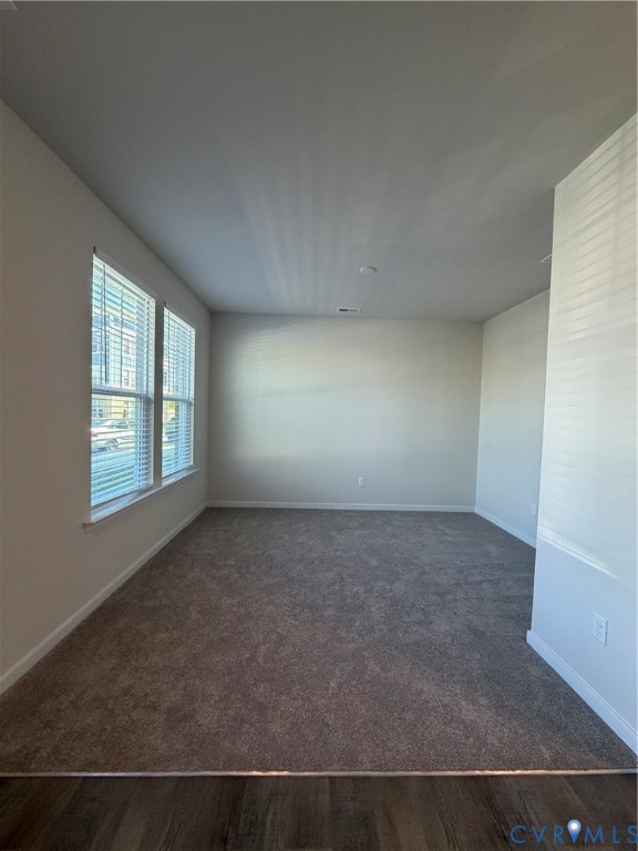 Carpeted living area featuring multiple windows with blinds, recessed lighting, and a wood-finish flooring transition