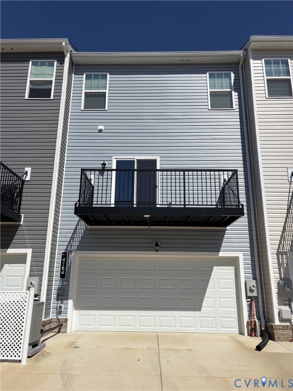 Multi-level townhome exterior featuring light blue vinyl siding