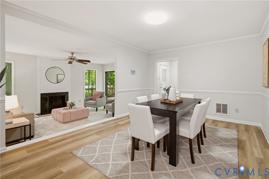 Dining area featuring wood-finish flooring, chair rail molding, and a flush-mount ceiling light Dining area featuring wood-finish flooring, chair rail molding, and a flush-mount ceiling light