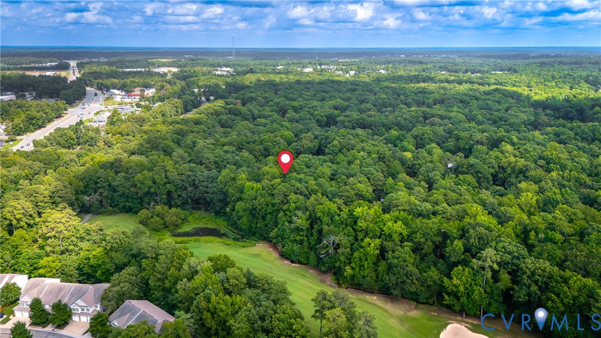 Expansive wooded property featuring mature tree canopy, rolling terrain, and open lawn areas