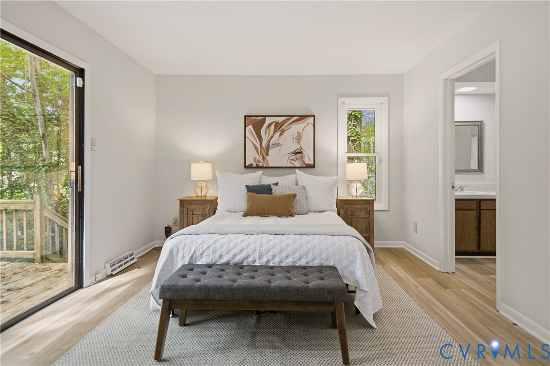 Bright room featuring light wood-finish flooring, a sliding glass door opening to an outdoor deck, and a single pane window