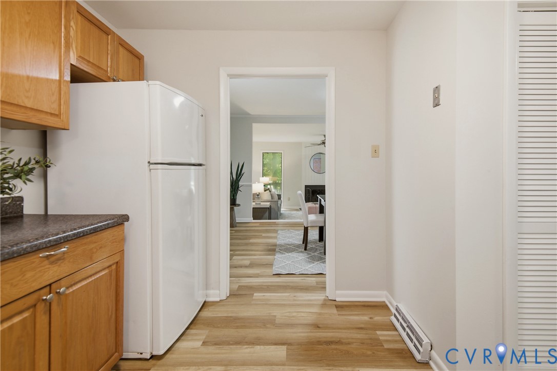 Kitchen area featuring wood cabinetry, a dark countertop, and a white refrigerator