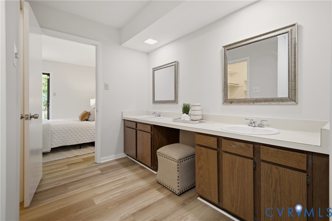 Dual vanity with wood-finish cabinetry and white countertops